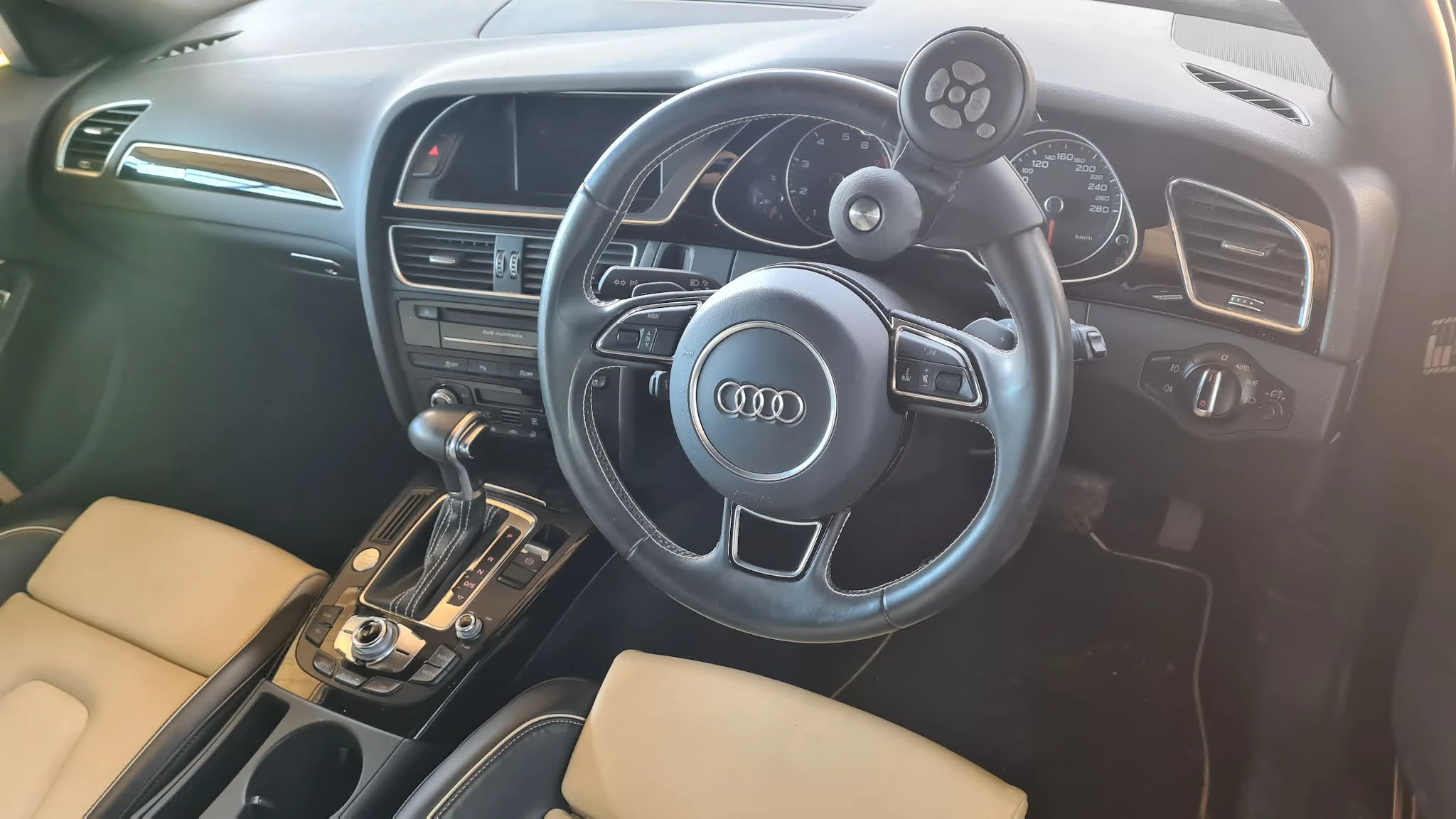 My multi-function spinner knob installed on the steering wheel of a right-hand-drive Audi, mounted at the upper-right position outside the airbag zone.